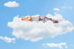 A woman sleeps on a cloud.