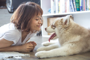 A woman looks at her dog and smiles. The dog has its tongue out.