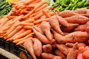 Yellow and orange vegetables are shown, such as sweet potatoes and carrots.