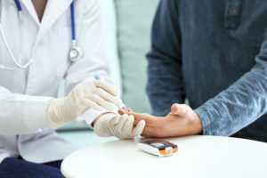 A medical professional conducts a hemoglobin A1C test on a patient.