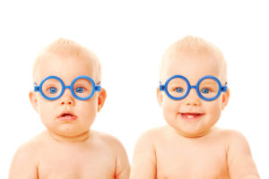 Twin babies are shown with blue glasses.