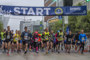An Amway River Bank Run race photograph is shown with runners at the starting line.